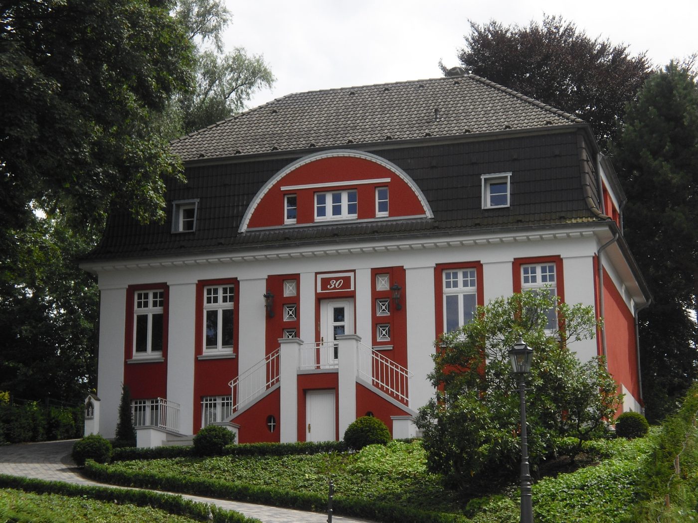 Buggenbeck: Villa mit roter Fassade und weißen Fenstern