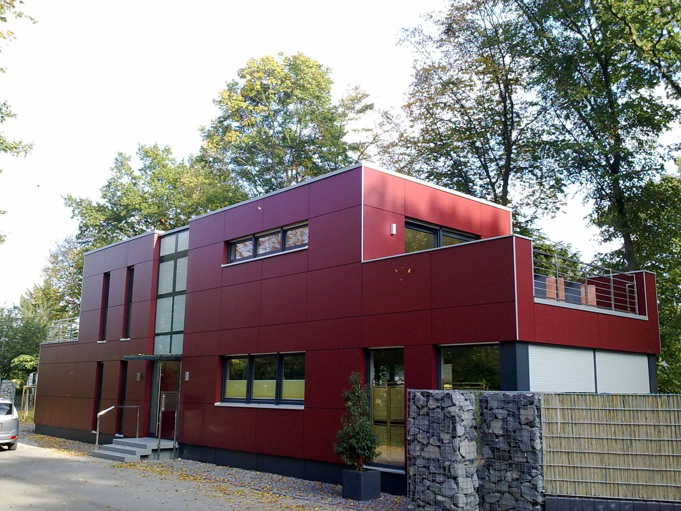 Eingang mit Glasvordach und Betonstufen