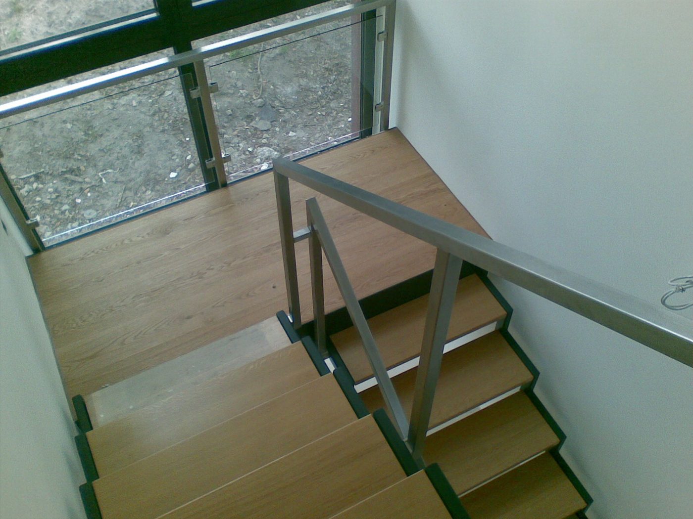 Treppe mit Holzstufen und Glasbrüstung